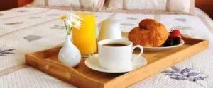 Breakfast on a bed in a hotel room